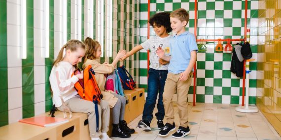 Kids interacting in a school locker room, showcasing friendship and happiness.