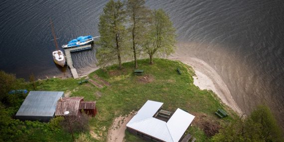 Aerial shot of a lakeside area with boats and picnic benches in Wdzydze Kiszewskie, Poland.
